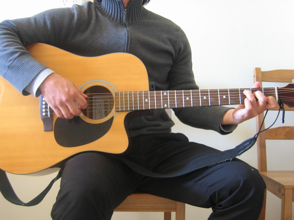 how to hold a guitar